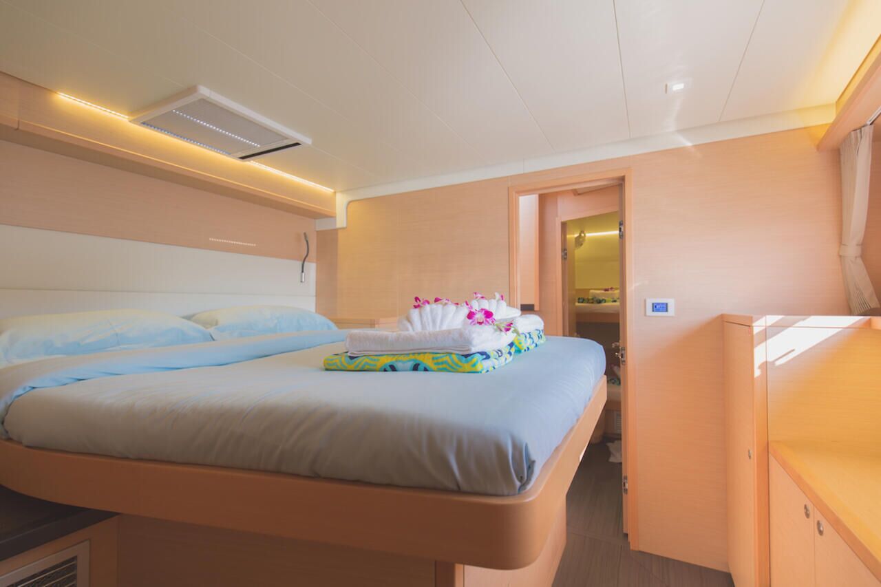 Une chambre d’hôtel comprenant un lit, une table de chevet, une armoire et une porte donnant sur une autre pièce.
