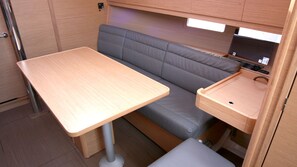 A compact kitchenette with a table, bench, and sink. - Sun-Kissed Sailing Adventure in Istria, Croatia (Pula)