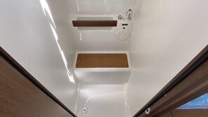 Un baño con un lavamanos blanco, un mueble de tocador de madera y un espejo.