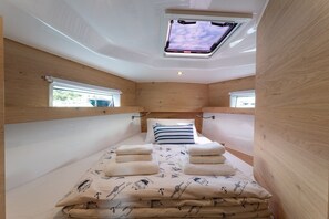 Ein kleines Zimmer mit Oberlicht, Etagenbetten und einem Fenster.