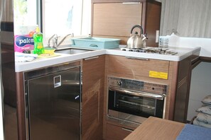A compact kitchen with a built-in oven, a sink, and a stove. - Dubrovnik Delight: A Sun-Kissed Sailing Experience (Komolac)