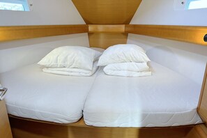 A compact bed with two pillows and a wooden headboard in a cabin-style room. - Sun-Kissed Sailing Adventure in Istria, Croatia (Pula)