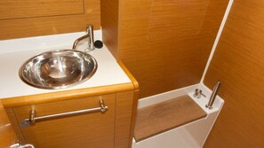 A compact kitchenette with a stainless steel sink, wooden cabinetry, and a white countertop. - Sun-Kissed Sailing Adventure in Istria, Croatia (Pula)