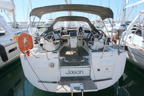 Un vaixell anomenat 'Jason' amarrat a una marina, amb diversos vaixells al fons.