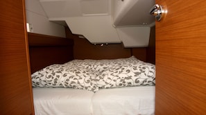 Un lit compact avec une literie à motifs dans une chambre au style rustique.