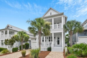 A two-story house with a porch, white siding, and a garage. - Gulfview on 30A (Santa Rosa Beach)
