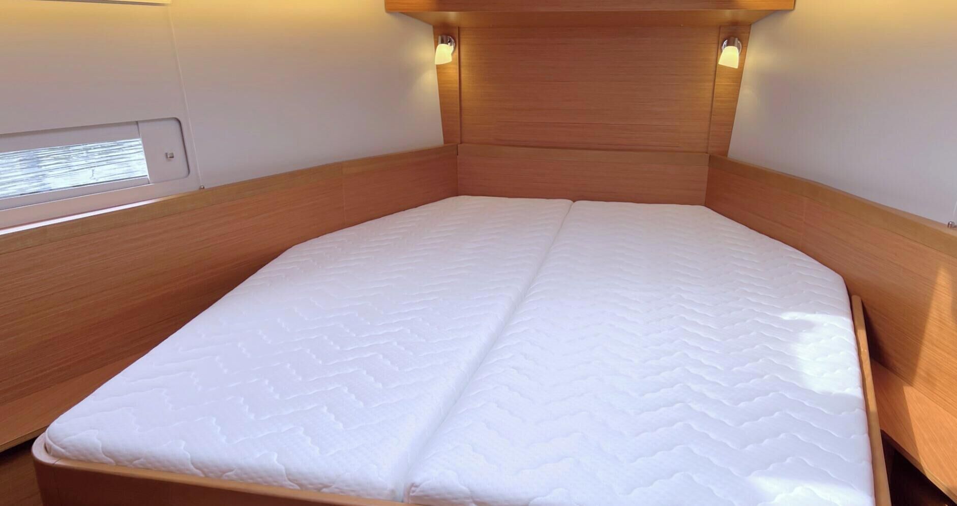 A small, single-bed room with a wooden headboard and bedside lamps.