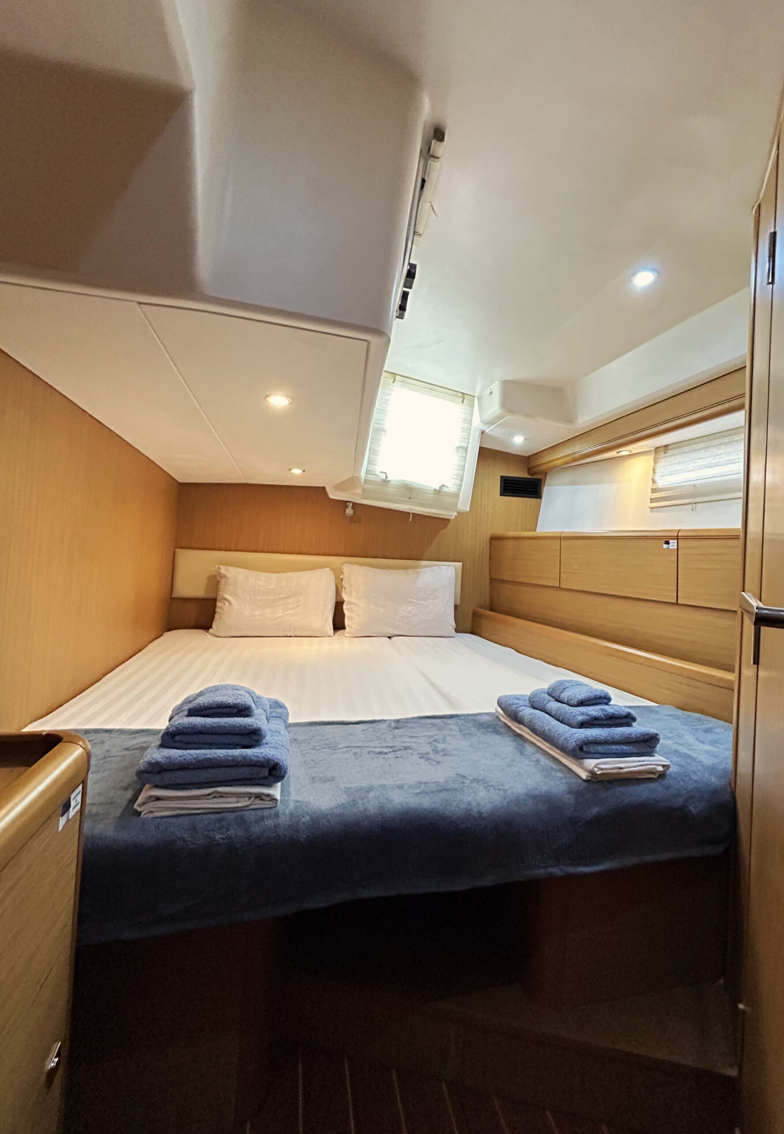 Een knus kamertje met een bed, een klein tafeltje en een raam.