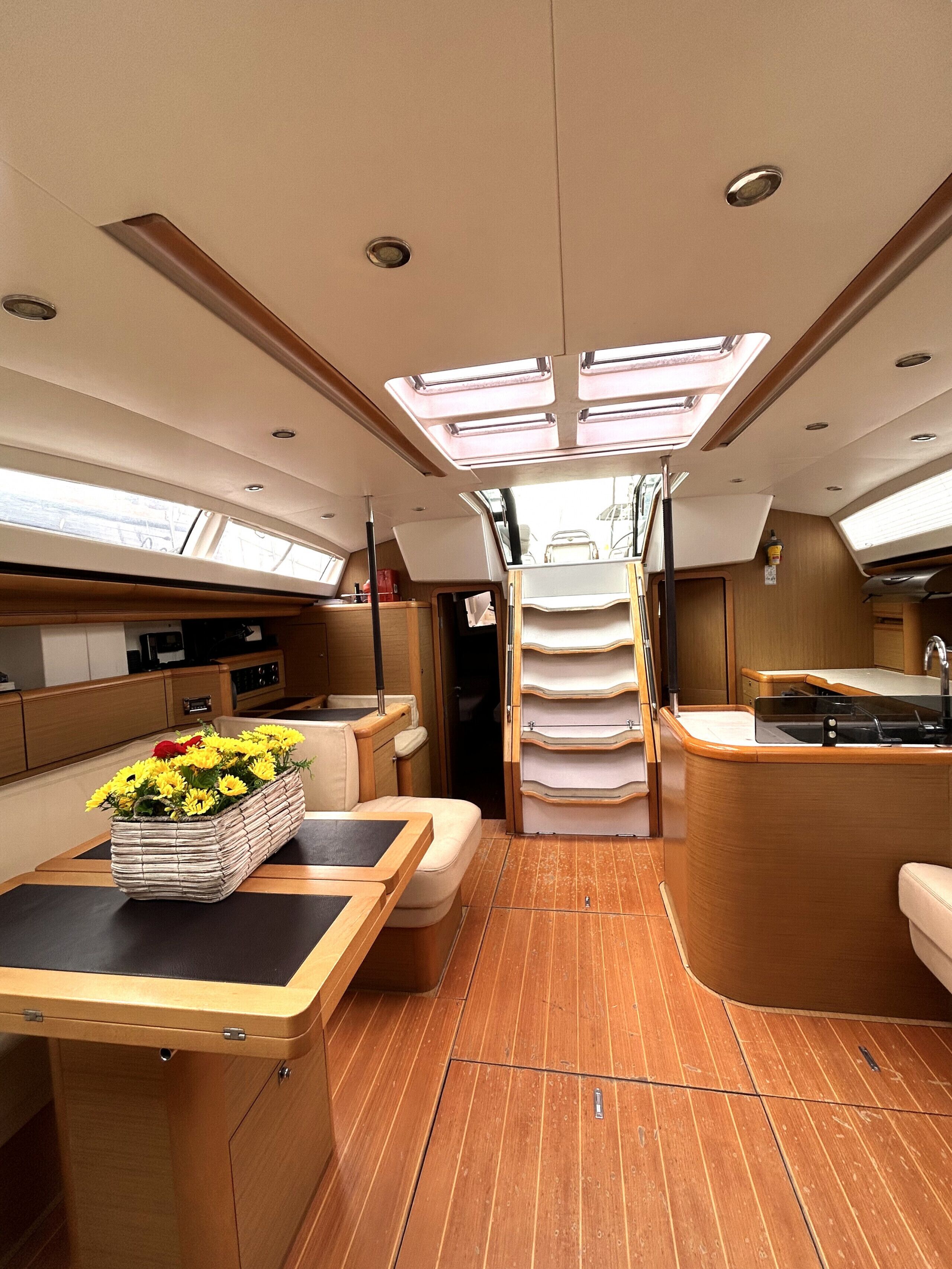 An interior with a kitchen, dining area, and a central passageway.