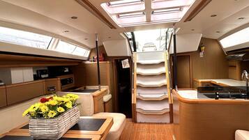 An interior with a kitchen, dining area, and a central passageway.