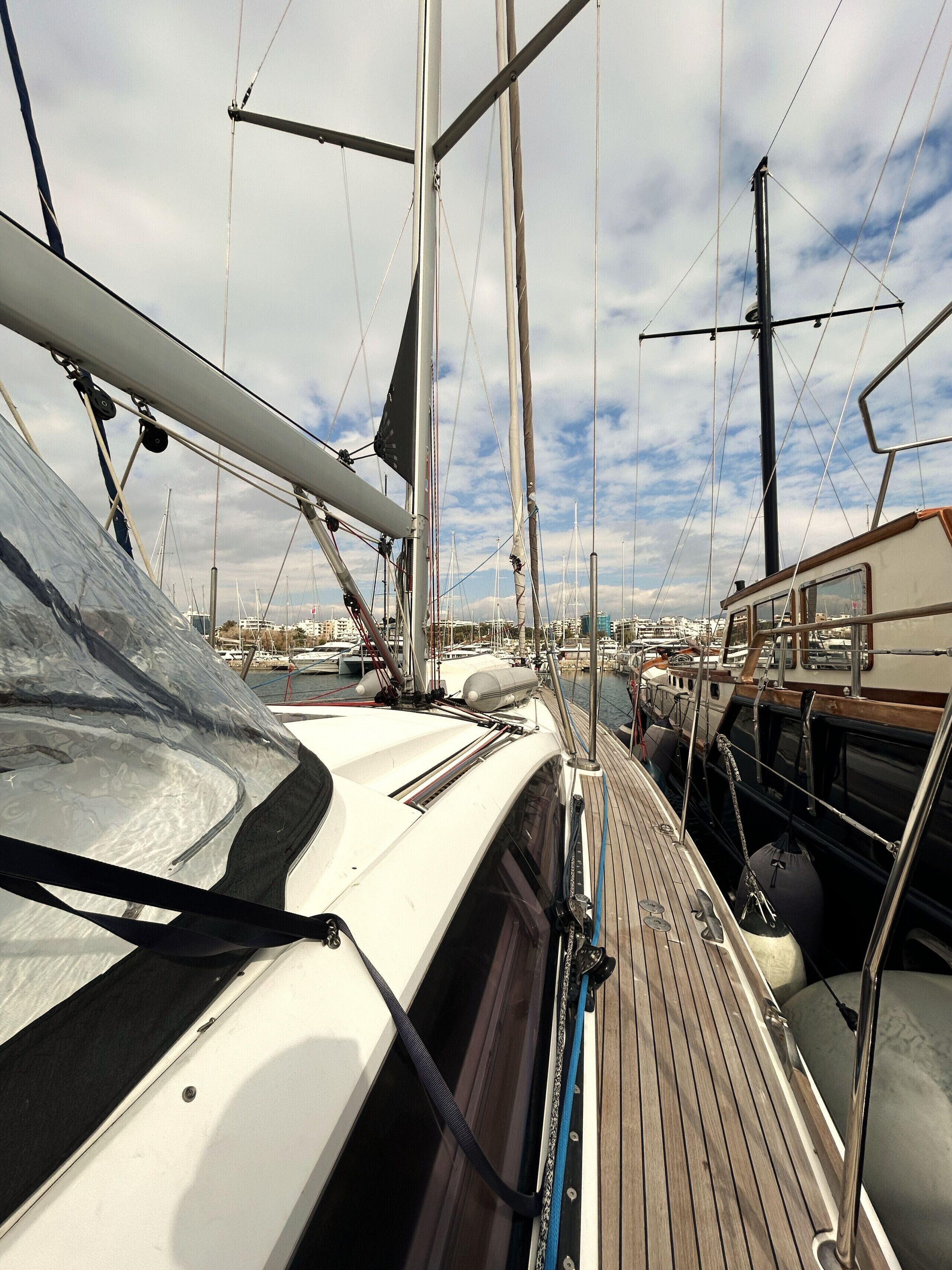 Ein Yachthafen mit vertäuten Booten, einem Holzdeck und Metallgeländern.