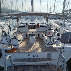 Ein Bootsdeck mit Steuerrad, Steuerstand und dem Namen 'Elisa' auf dem Boden.