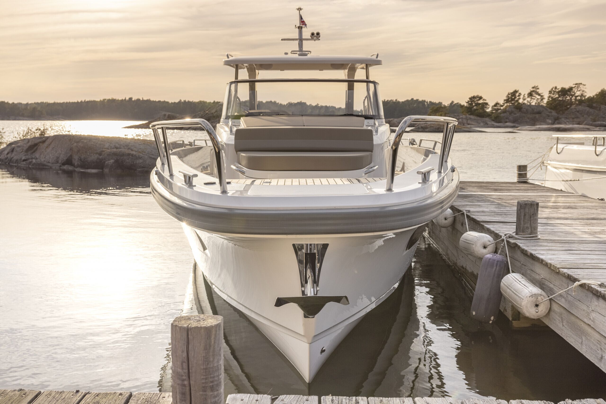 A boat docked at a pier with a clear view of the water and distant shoreline.