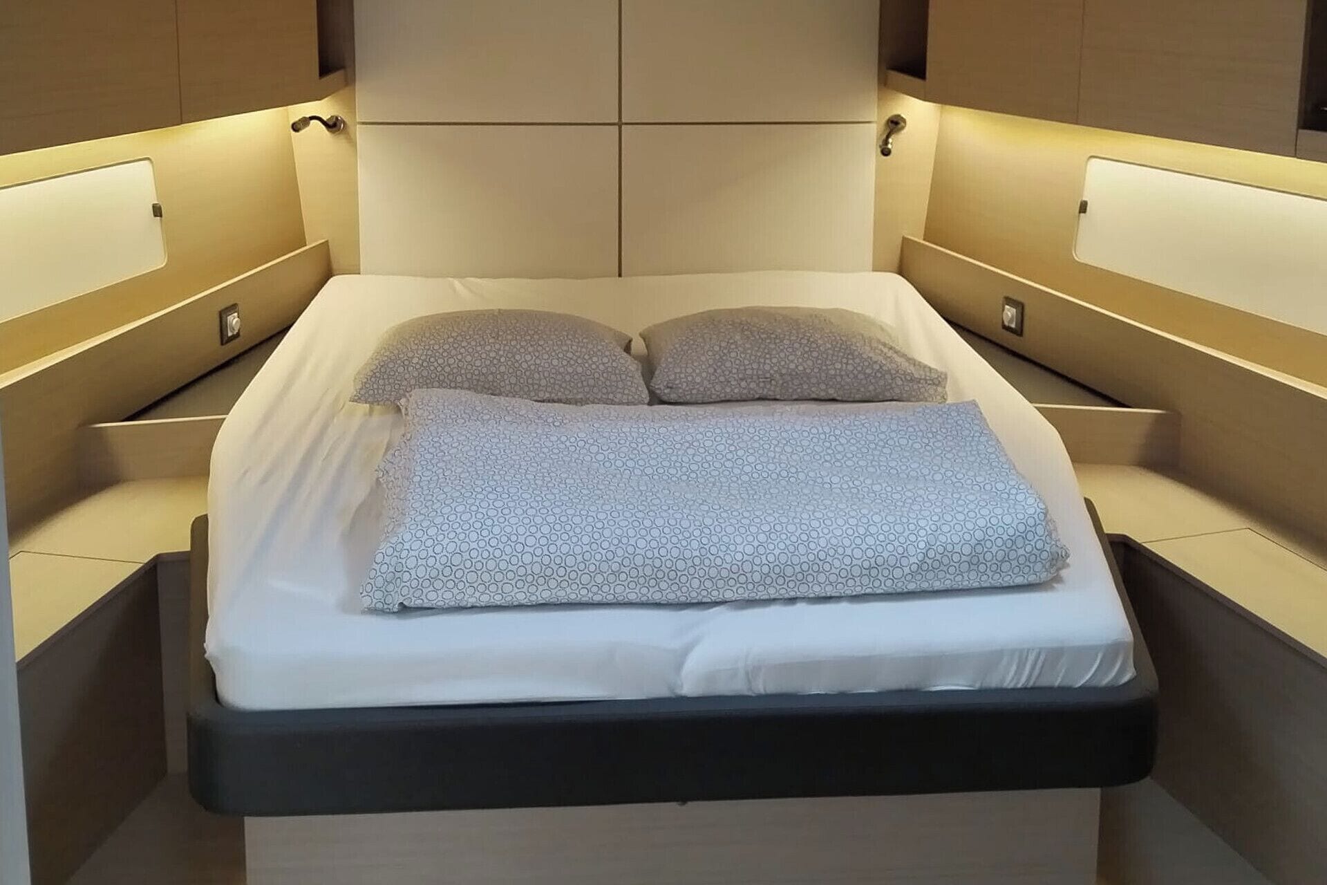Un letto moderno con una testiera, due cuscini e una coperta.