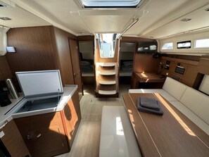A compact RV interior with a kitchenette, a bed, a seating area, and a control panel. - Sun-Kissed Sailing Adventure in Zadar, Croatia (Biograd na moru)