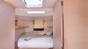 A compact, well-lit room with a skylight, a bed with pillows, and built-in shelves. - Sun-Kissed Sailing Adventure in the Ionian Islands, Lefkada (Lefkada)
