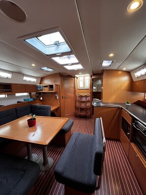 A compact, well-lit interior with a dining area, seating, and a kitchenette. - Sun-Kissed Sailing Adventure in Zadar, Croatia (Bibinje)