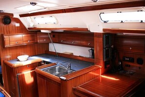 A compact galley with wooden cabinetry, a sink, and a small countertop. - Sun-Kissed Sailing Adventure in Istria, Croatia (Pula)
