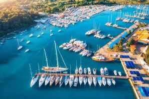 An aerial view of a marina with numerous boats docked, surrounded by greenery and buildings. - Sun-Kissed Sailing Adventure in Istria, Croatia (Pula)