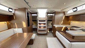 Een compact, goed verlicht interieur met een eetgedeelte, een kitchenette en een zithoek.