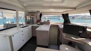A compact galley with a sink, stove, and small refrigerator, with a view of the marina. - Sun-kissed Sailing Adventure in Split-Dalmatia, Croatia (Seget Donji)