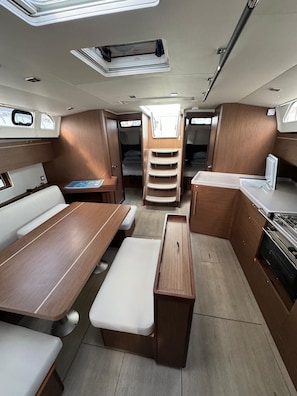 A compact interior with a dining area, a kitchen, and a seating area with a view through the windows.