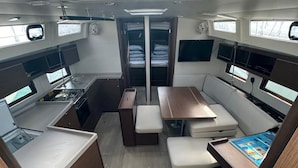 Een compact interieur met een kitchenette, zithoek en een kleine tafel met een spel.