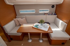 A compact, well-lit interior with a wooden table, cushioned seating, and a small window. - Sun-Kissed Sailing Adventure in the Ionian Islands, Lefkada (Lefkada)