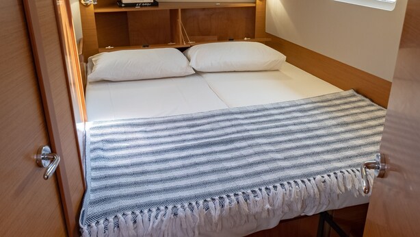 Ein gemütliches, helles Schlafzimmer mit Bett, Nachttischlampen und einem Oberlicht.
