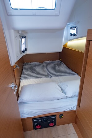 A compact bed with a headboard, a control panel below, and a small window above. - Sun-Kissed Sailing Adventure in the Ionian Islands, Lefkada (Lefkada)