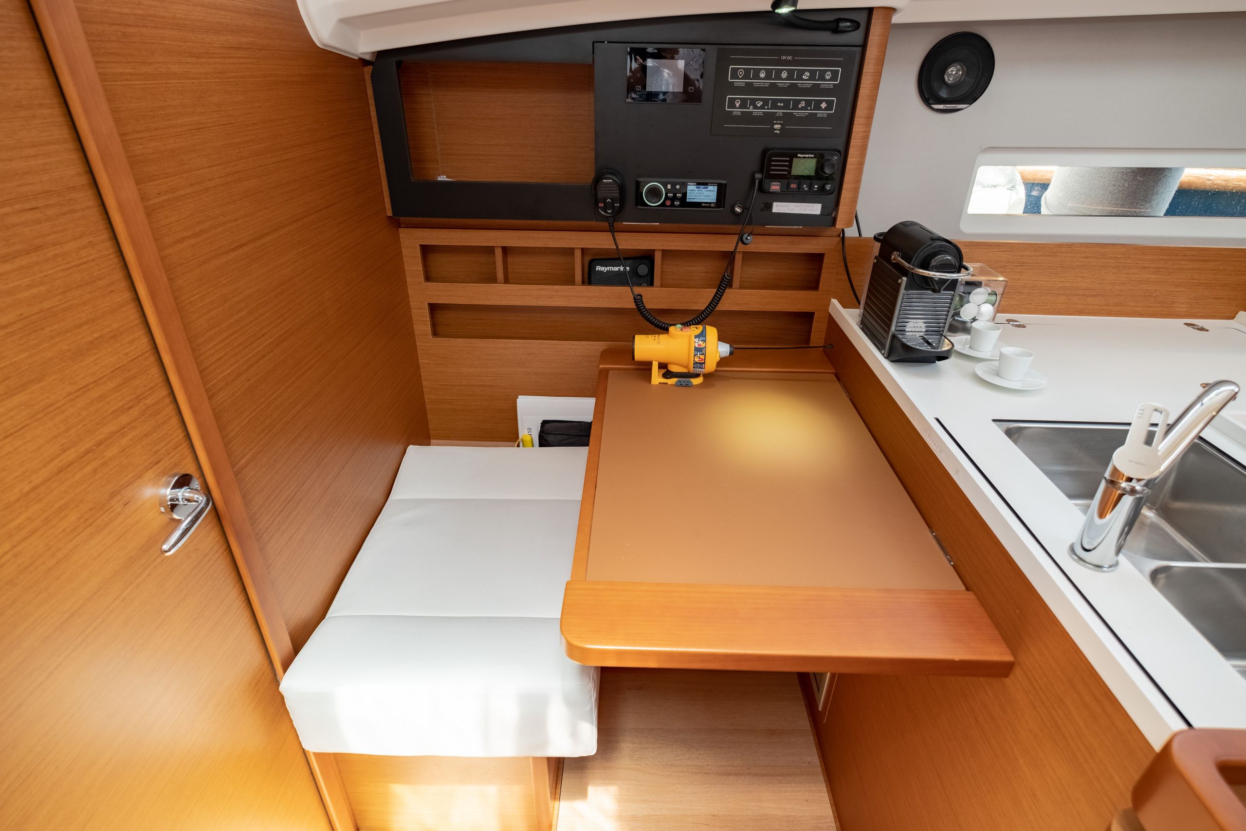 A compact kitchenette with a stove, sink, and storage cabinets.