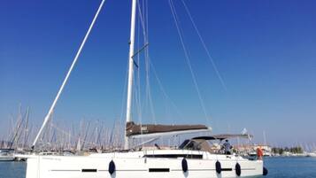 A sailboat docked at a marina with multiple other boats in the background.