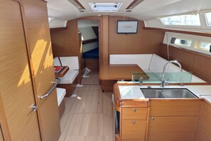 A compact galley with a sink, a small table, and a bench. - Sun-Kissed Sailing Adventure in Northern Croatia (Punat)