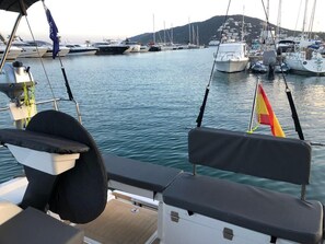 A marina with boats docked, a flag, and a view of the water.