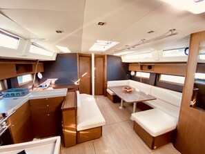 A compact interior with a kitchenette, seating area, and a table. - Sun-Kissed Sailing Adventure in the Ionian Islands, Lefkada (Lefkada)