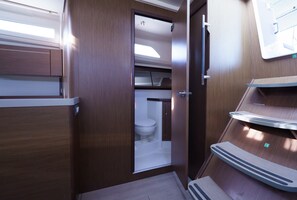 Ein kleines, modernes Badezimmer mit Toilette, Waschbecken und Duschbereich.