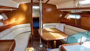 Un interior acogedor con una mesa central, asientos mullidos y un ventanal pequeño.