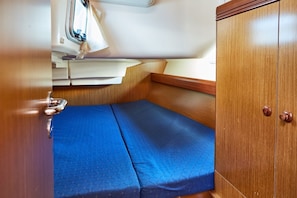 Una cabina compatta con un letto a castello, mobili in legno e una piccola finestra.