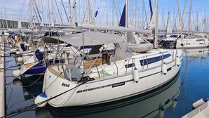 Marina con varios veleros amarrados, destacando una cabaña con vistas al agua.