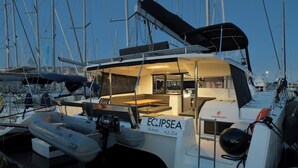 Ein Yachthafen mit einem Boot namens 'ECLIPSEA' im Liegehafen, mit einem überdachten Deckbereich, einer Kontrollstation und einem sichtbaren Rettungsring.