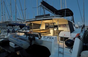 Ein Yachthafen mit einem Boot namens 'ECLIPSEA' im Liegehafen, mit einem überdachten Deckbereich, einer Kontrollstation und einem sichtbaren Rettungsring.