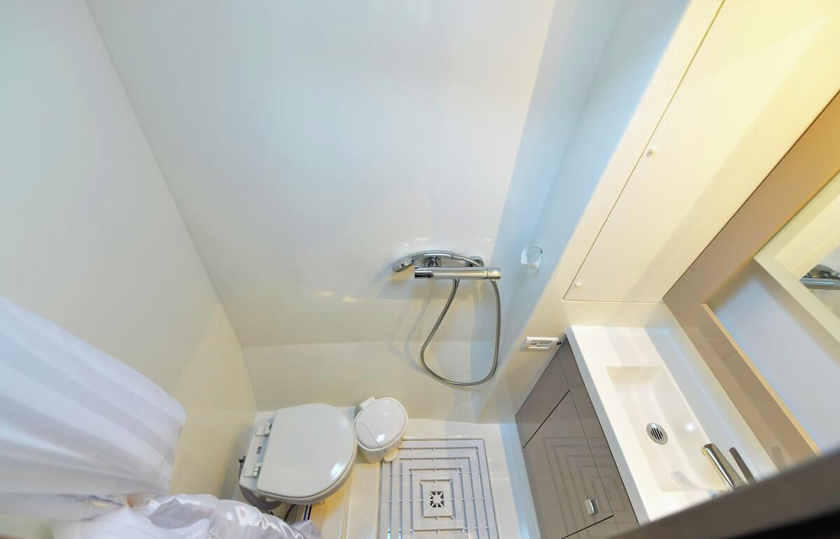 Ein kleines Badezimmer mit Toilette, Dusche und Waschbecken.