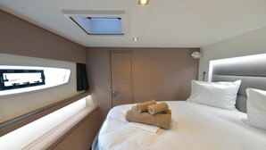 Ein Hotelzimmer mit Bett, Wandfernseher, Tür und Fenster.