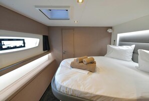 Ein Hotelzimmer mit Bett, Wandfernseher, Tür und Fenster.