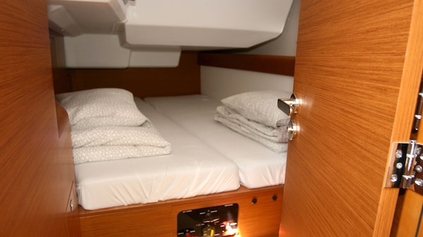 A compact cabin with a bunk bed, a small control panel, and a storage compartment.