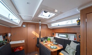 A compact RV interior with a dining area, kitchenette, and a small seating space. - Sibenik Sun-soaked Sailing: A Luxurious Croatian Voyage (Pirovac)