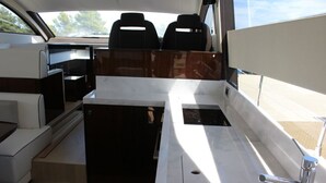 Interior d'una embarcació amb seients, un rentaplat i una finestra.