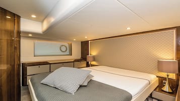 Une chambre moderne avec un lit, des tables de chevet, une tête de lit et une fenêtre avec des stores.