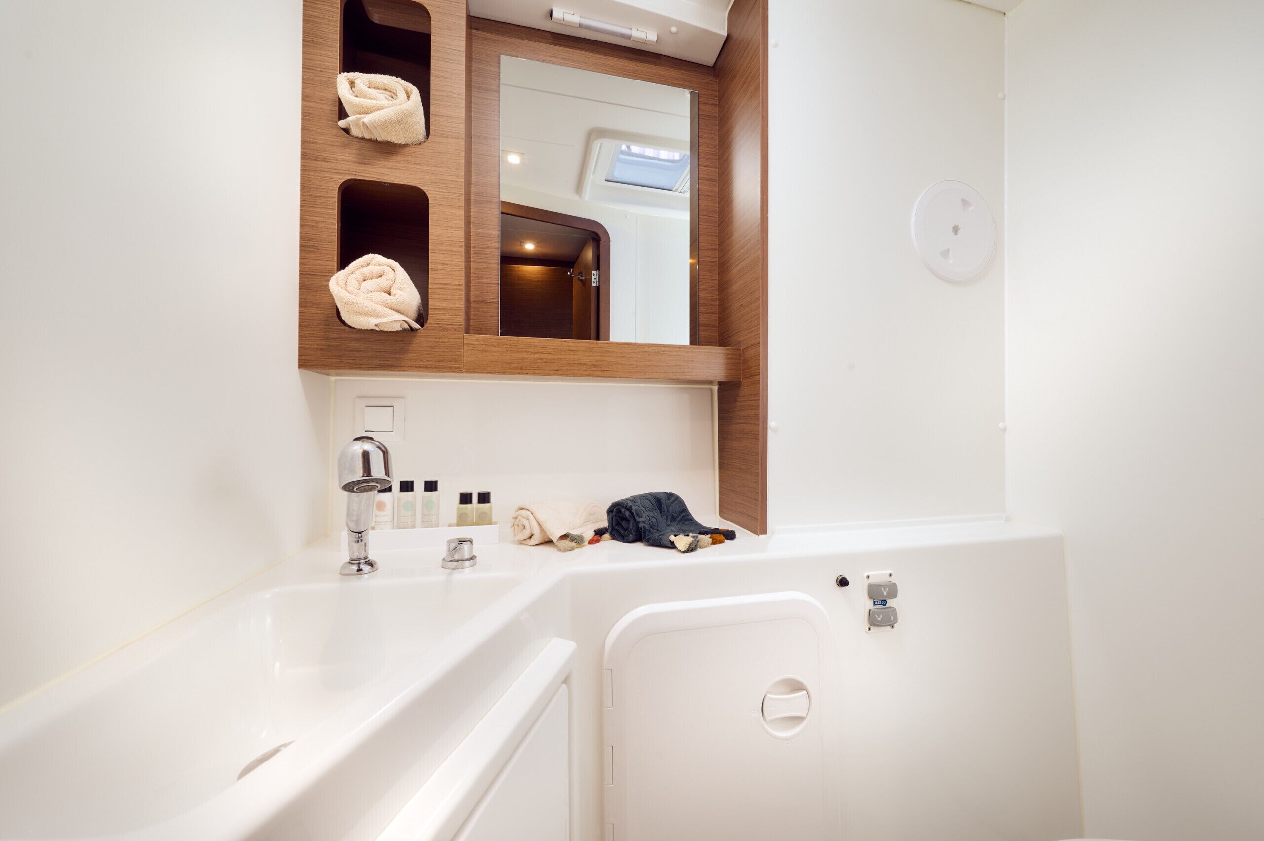 A modern bathroom with two sinks, a mirror, and a towel rack.