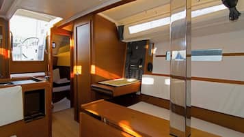 A compact, well-lit interior with a kitchenette, a small table, and a seating area.